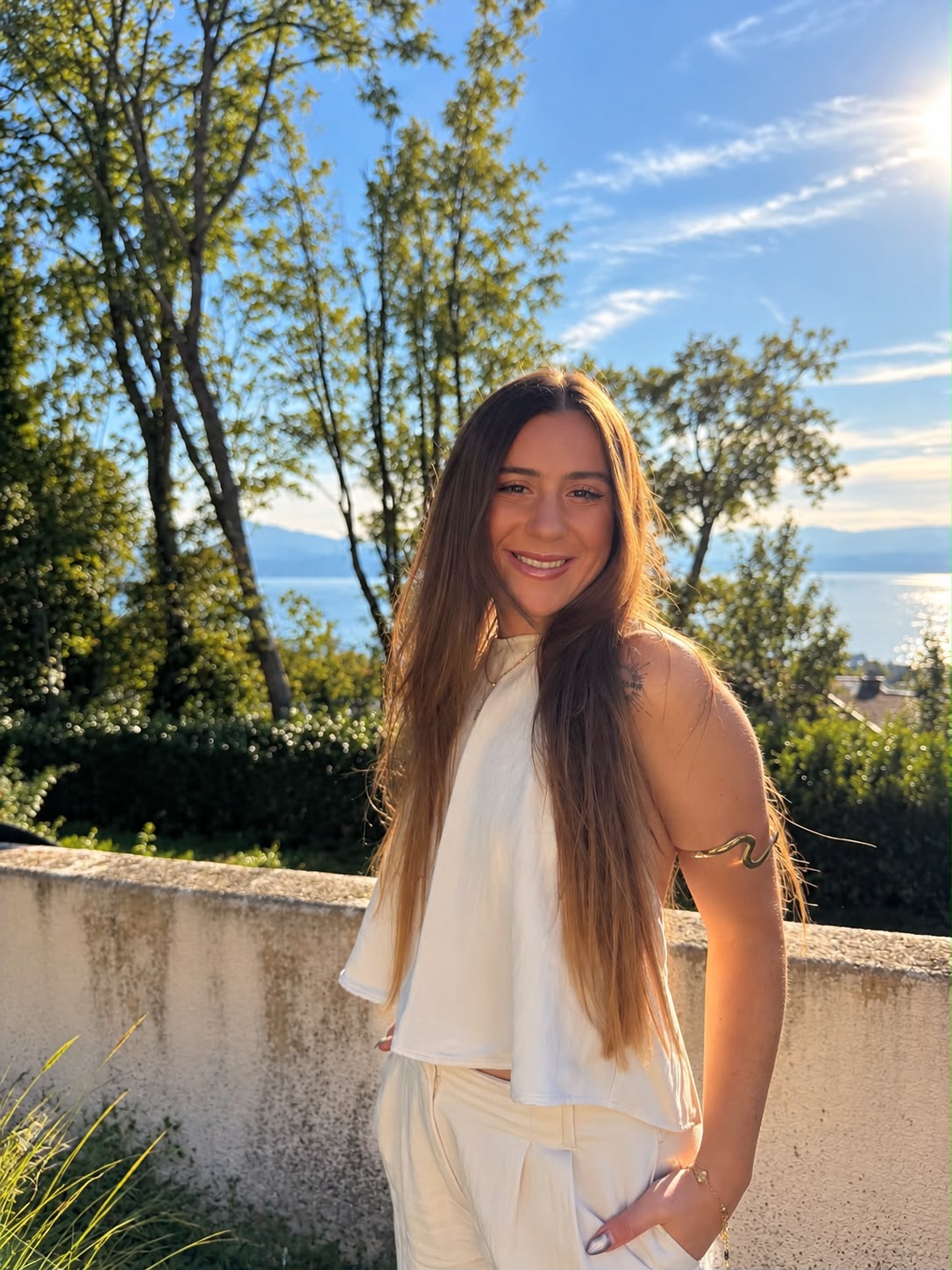 Lisa souriante dans la lumière, avec le lac Léman en arrière-plan